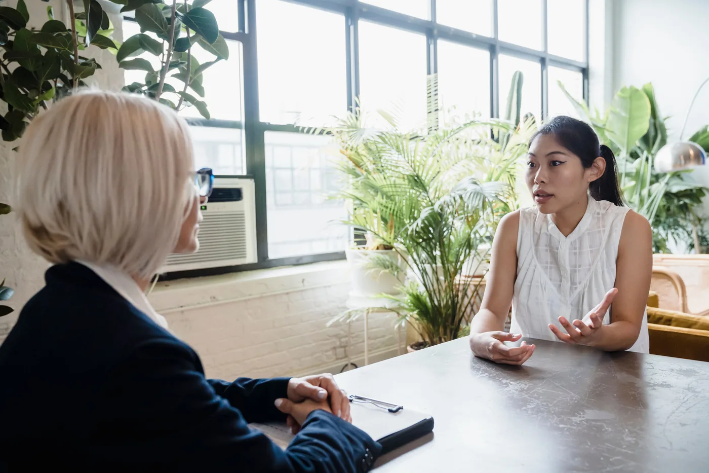 Entretien d'accompagnement entre une conseillère et une cliente autour d'une table de réunion