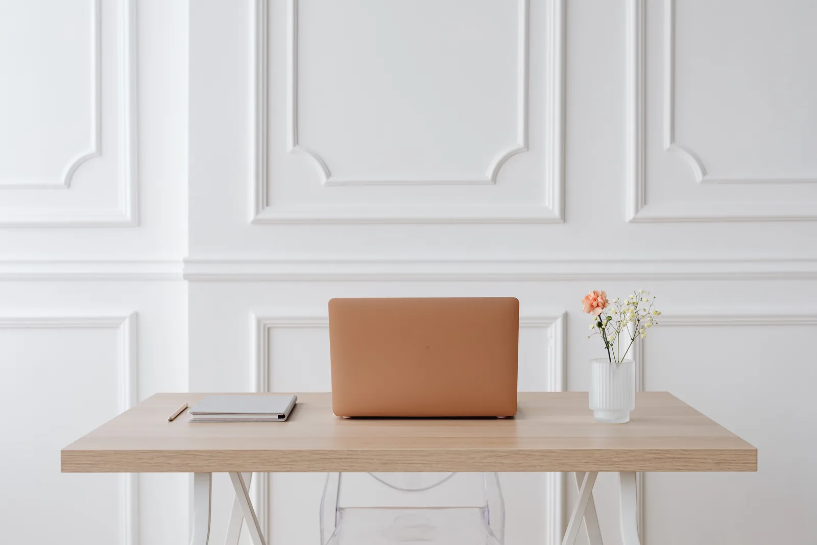 Bureau clair et ordonné avec ordinateur portable, carnet et fleurs
