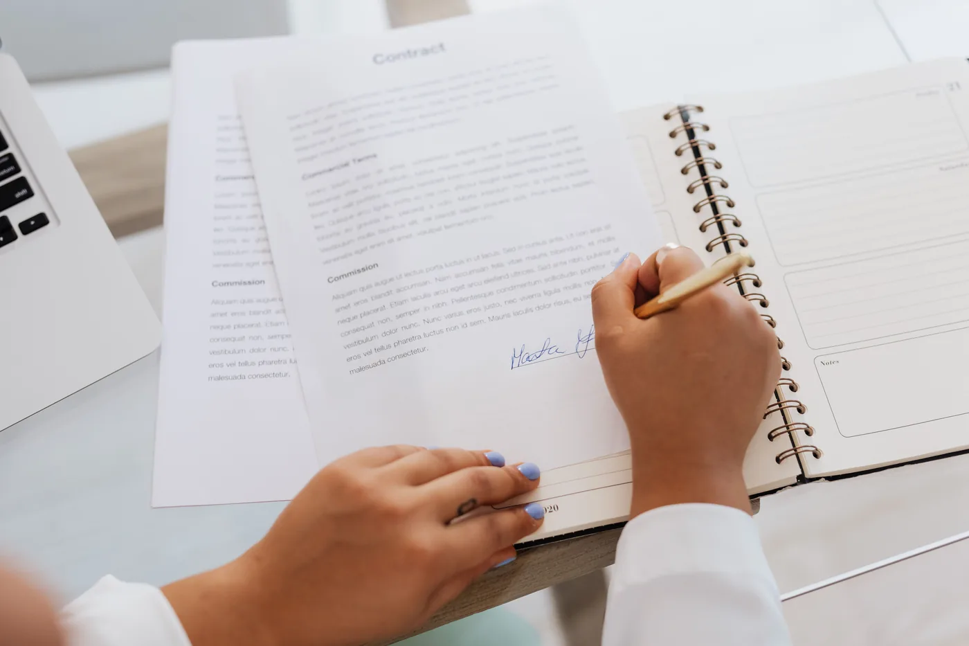 Signature d'un contrat de constitution de société, documents et carnet de notes sur un bureau