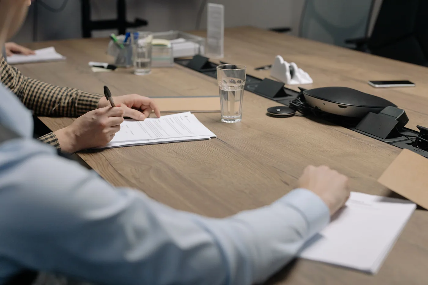 Revue et signature de documents autour d'une table de réunion en bois
